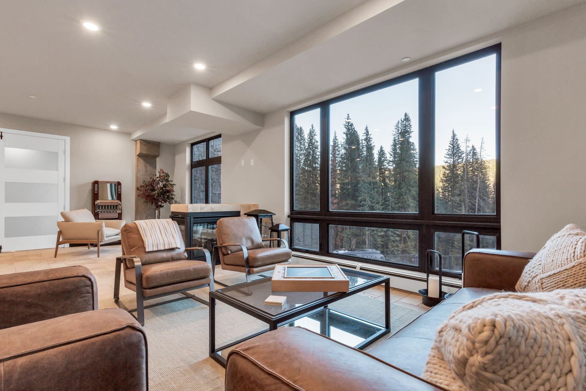 The club lounge looking out through tall windows to snow-covered pines